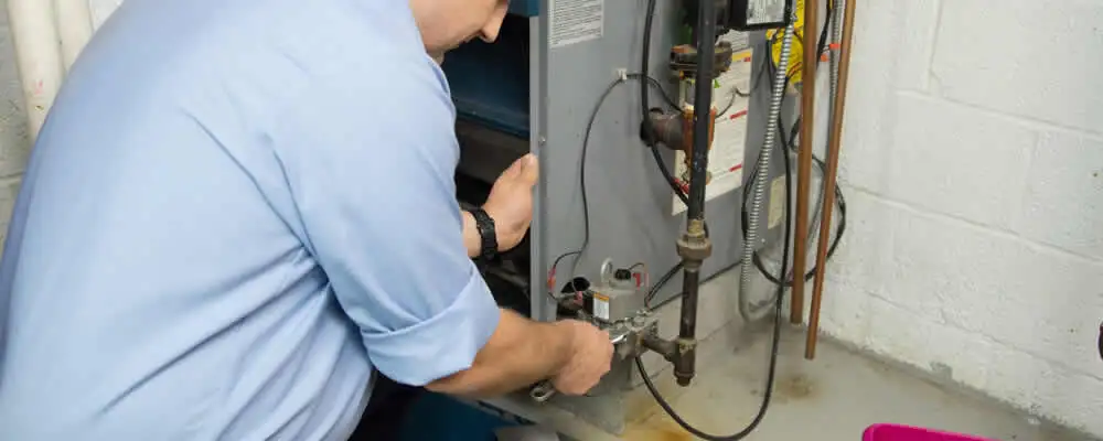 Furnace repair technician inspecting and servicing a home heating system in Anaheim, CA