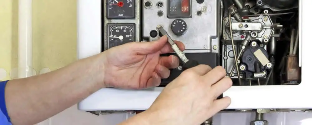 Heating repair technician adjusting boiler controls and components in Anaheim, CA