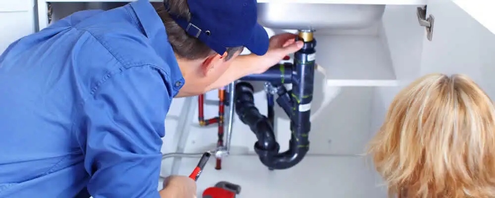 Plumber repairing under-sink drain pipes and fittings in Anaheim, CA